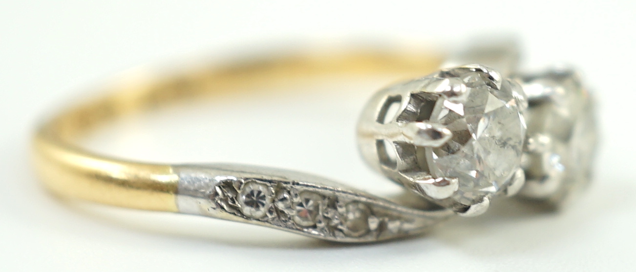 A mid 20th century 18ct gold, platinum and two stone diamond set crossover ring